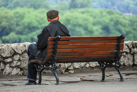 一个孤独的老人独自坐在长凳上