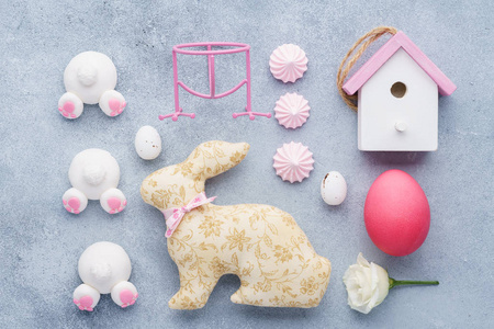 复活节创意装饰布局。 兔子玩具屋兔子屁股糖果和鸡蛋。 粉红色。 平躺着