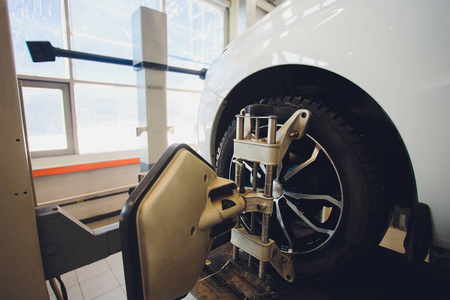 汽车在汽车方向盘平衡器和校准与激光反射器附加在每个轮胎中心驾驶调整在车库