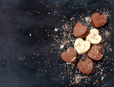 黑巧克力心情人节背景家庭制作巧克力黑白色的心在黑色破旧的冲浪顶部