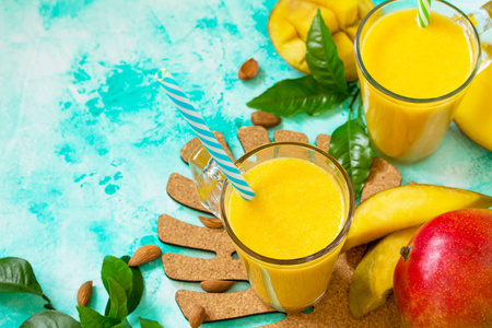 超级食品和健康或排毒饮食的概念。石桌上放满芒果的玻璃瓶中水果热带冰沙..新鲜的有机冰沙原料。复制空间。