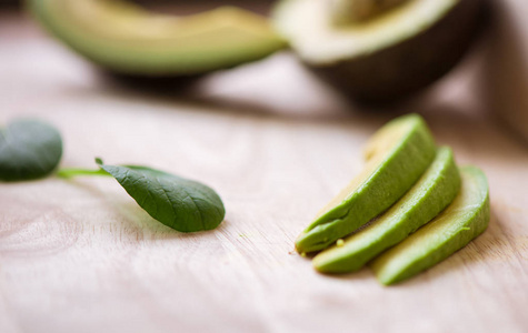 木桌上一个新鲜多汁的绿色成熟鳄梨。健康食品概念。