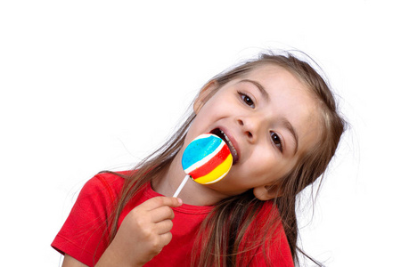 小女孩在工作室里吃五颜六色的棒棒糖的肖像。