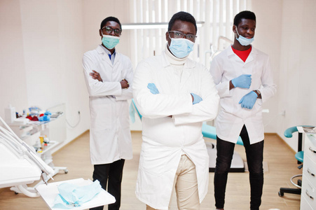 三名非裔美国男性医生，交叉手臂在牙科诊所。