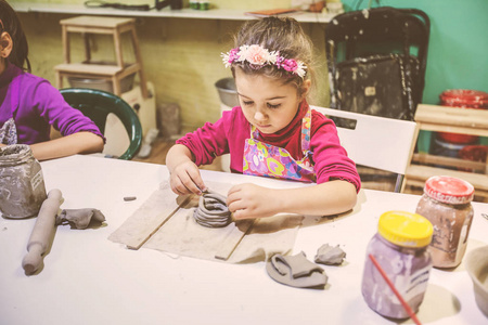 儿童陶器车间小女孩与粘土创造性学习。