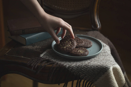 s hand takes a cookie from the plate.