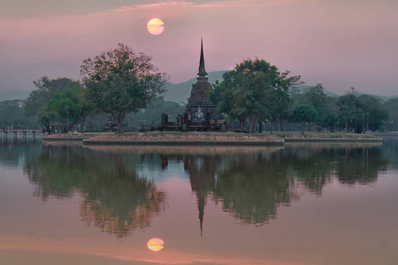 泰国苏科泰历史公园瓦萨寺佛像大塔和太阳的美丽早晨景观和镜子照片