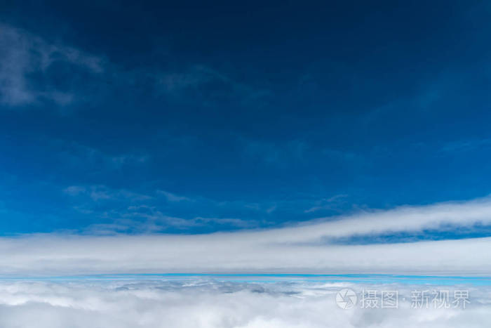 深蓝色的天空地平线上升起从飞机窗口观看