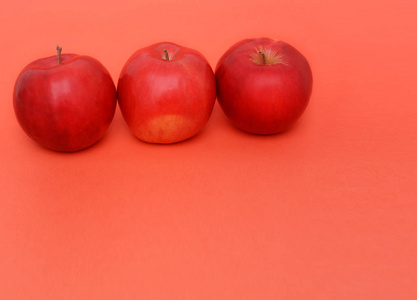 红色背景上的三个红苹果