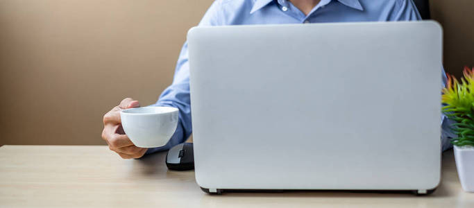 年轻的商人使用笔记本电脑分析营销计划，早上喝咖啡。 商业金融和生活方式概念