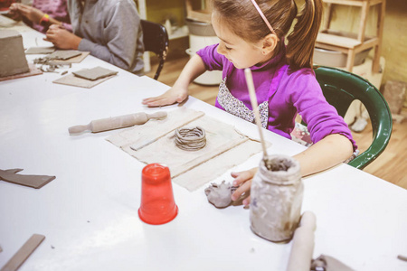 儿童陶器车间小女孩与粘土创造性学习。
