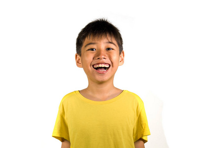 年轻快乐兴奋的孩子的肖像，微笑欢笑欢快，穿着白色背景上的黄色T恤，在孩子的快乐和快乐的脸上表达概念