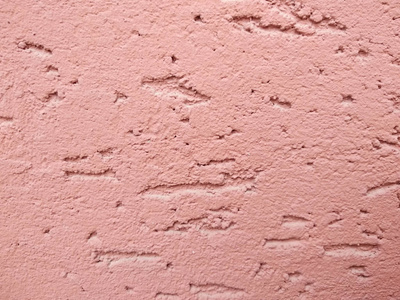 粉红色的装饰石膏。石膏树皮甲虫的质地。抽象粗糙的背景