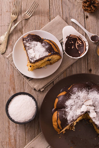 木制桌子上有可可馅的巧克力椰子蛋糕。