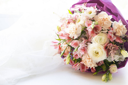 婚礼花束由淡紫色工艺纸的白花和白玫瑰制成