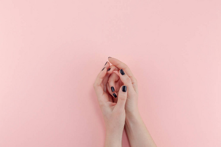 s hands on millennial pink pastel background. Beauty and SPA con