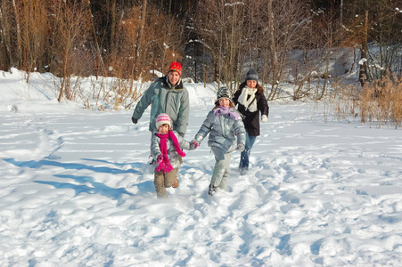 快乐的家庭在冬天散步，玩得开心，周末在户外玩雪