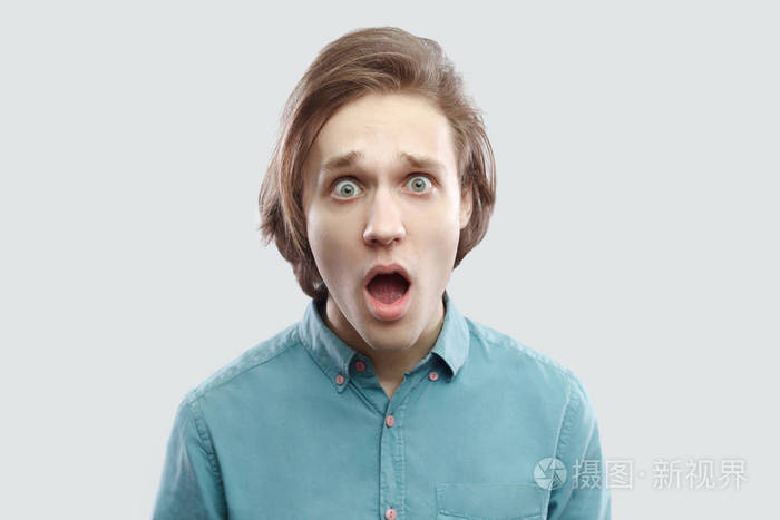 一张惊呆了的金发碧衫男子的照片,他睁大眼睛张大嘴巴,惊讶地看着镜头