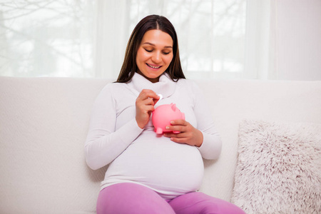 快乐的孕妇为她的孩子省钱。