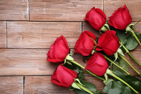 棕色木桌上的一束红玫瑰