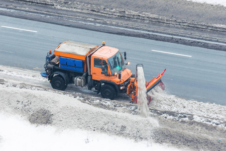 机械雪犁清洁公路，拆除清洁雪摆在路边。