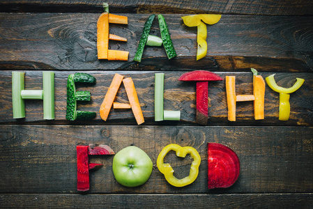 吃健康的食物，新鲜的蔬菜，平躺在深色的木制桌子上。 营养有机粉配料概念。 不错的烹饪明信片海报横幅。