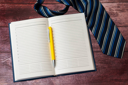打开干净的商务笔记本和笔，记录重要事件和与商业伙伴在木桌上的会议
