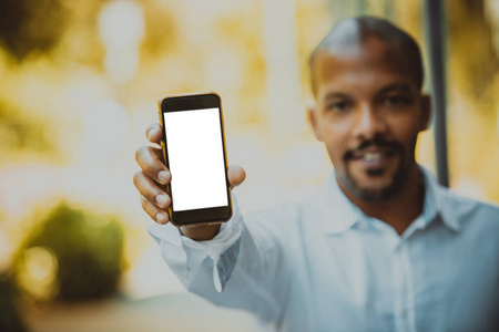 年轻的非洲黑人企业家在与商业伙伴见面前, 拿着带有广告内容复制空间屏幕的手手机