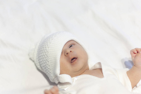戴着针织帽子的新生婴儿躺在白色的背景上