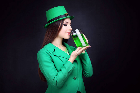 s Day. Beautiful woman wearing green hat and drinking beer