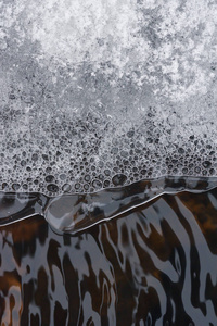在湍流水流的背景下，气泡在薄冰壳下的积累。