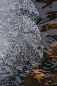 在湍流水流的背景下，气泡在薄冰壳下的积累。