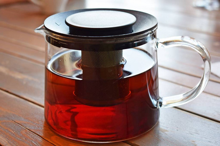 新鲜的香红茶在一个木制的玻璃茶壶上。