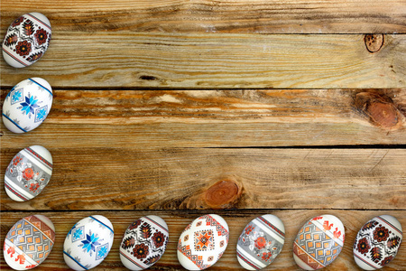 快乐复活节卡片。 木制桌子背景上五颜六色闪亮的复活节彩蛋。 文本复制空间