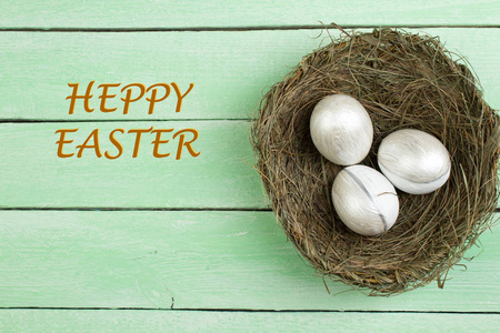 复活节快乐。 顶部视图巢与油漆鸡蛋在木桌上。 文本复制空间