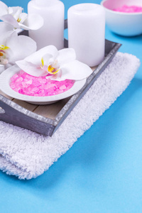 用蓝色背景的兰花蜡烛肥皂和毛巾为静物做水疗