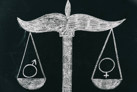 绘制黑板上性别平等概念的天平上的男女标志