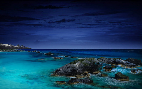 夜晚的色彩夜晚的海洋作为自然背景,壮丽的海洋景观和北极光与岩石.