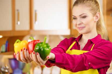 搞笑快乐的女人拿着香椒，美味健康的减肥蔬菜，呈现减肥食品。