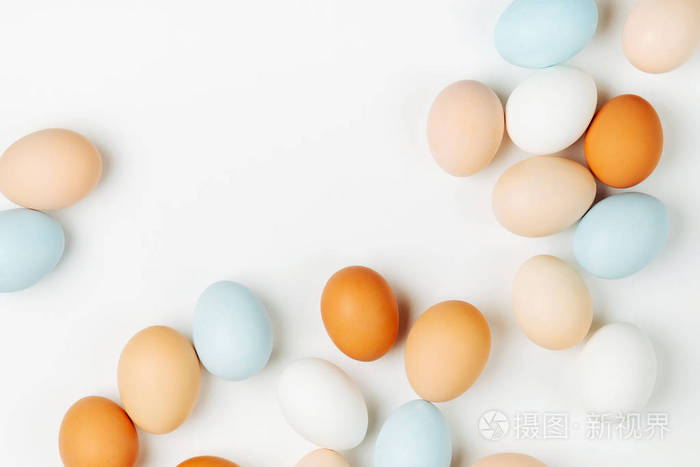 浅色背景下的天然彩色棕色和白色鸡蛋.粉彩的构图.复活节.平躺,俯视