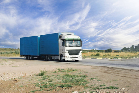 货运出租带白色出租车的蓝色卡车在高速公路上行驶照片