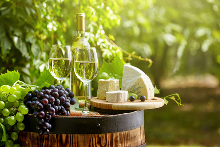 花园露台木桶上的葡萄和白葡萄酒
