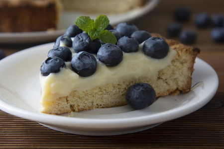 健康的甜点。 一块蓝莓馅饼或带奶油的蛋糕。 新鲜甜甜点和水果。 上面的风景。