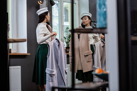 乌格黑发亚洲漂亮的女人在时尚的头饰站在镜子前