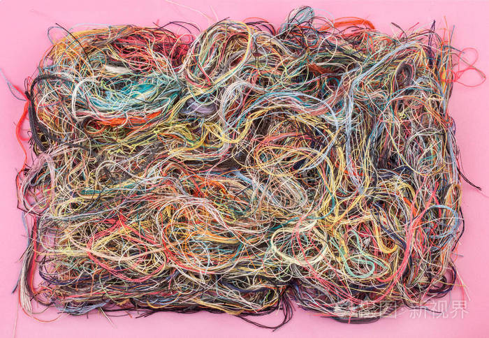 粉红色背景上五颜六色的缠绕线特写镜头