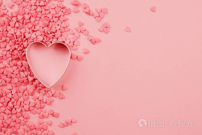 美丽的情人节背景与烘焙模具心形和珊瑚粉红色糖果心粉红色单色纸