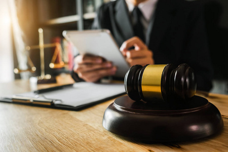在法庭上，法官用木桌上的智能手机笔记本电脑和数字平板电脑工作。