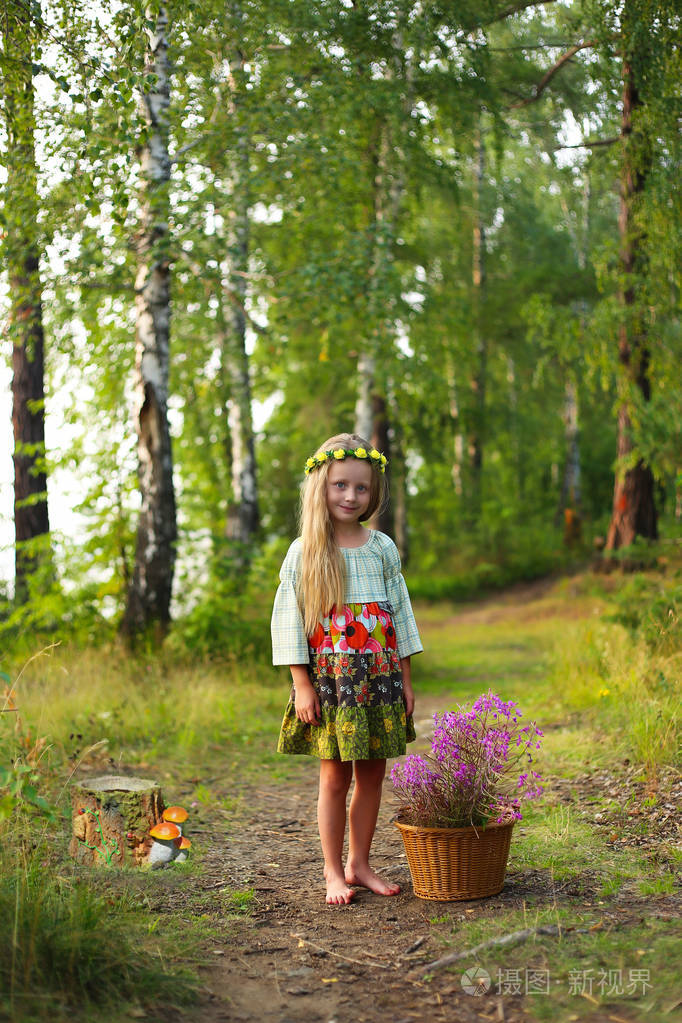 可爱的小女孩在森林路上带着一篮子花a