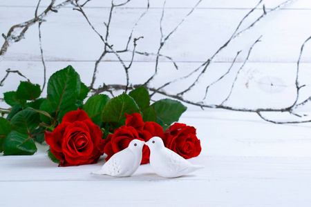 情人节家庭室内装饰,白色亲吻鸽子的瓷质雕像,花枝覆盖着海霜和红玫瑰