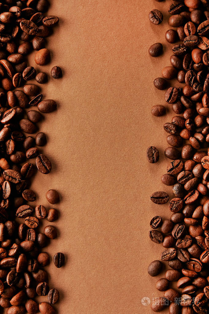 新鲜烤咖啡豆散落在棕色的桌子上有很多复制空间供文字平躺构图关闭